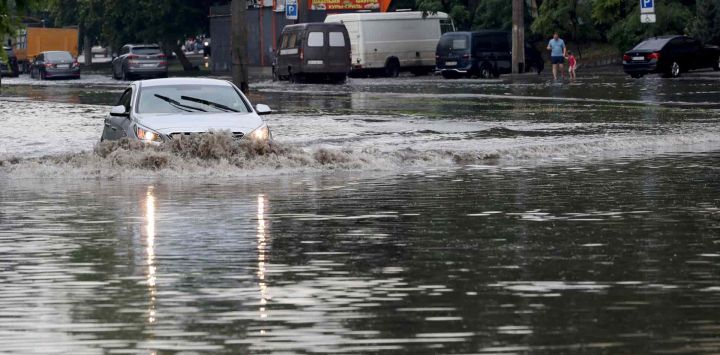 Un automóvil conduce por una calle inundada luego de fuertes lluvias en la ciudad ucraniana de Odessa, en el Mar Negro. Oleksandr GIMANOV / AFP.