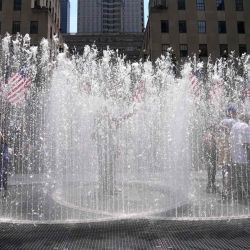 La gente juega en la escultura a base de agua del artista Jeppe Hein titulada "Changing Spaces", una instalación de arte público interactivo en el Center Plaza del Rockefeller Center en Nueva York. TIMOTHY A. CLARY / AFP. | Foto:AFP