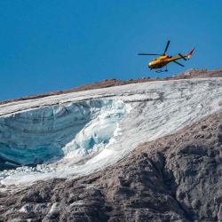 Un helicóptero de rescate vuela sobre el glaciar que se derrumbó en la montaña de Marmolada, la más alta de los Dolomitas. Los equipos de rescate reanudaron la búsqueda de sobrevivientes. Pierre TEYSSOT / AFP. | Foto:AFP