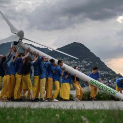 Activistas de Greenpeace levantan un aerogenerador facticio en el borde del lago Lugano durante una manifestación que pide una reconstrucción sostenible de Ucrania. Fabrice COFFRINI / AFP. | Foto:AFP