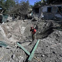 Un trabajador se para en un cráter frente a una casa gravemente dañada en una zona residencial de Kramatorsk, el día después de un ataque con cohetes rusos. Genya SAVILOV / AFP. | Foto:AFP