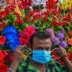 Un vendedor de flores artificiales usa máscaras faciales distribuidas por trabajadores de la salud como protocolo de seguridad para frenar la propagación del coronavirus Covid-19 en Kolkata. DIBYANGSHU SARKAR / AFP. | Foto:AFP