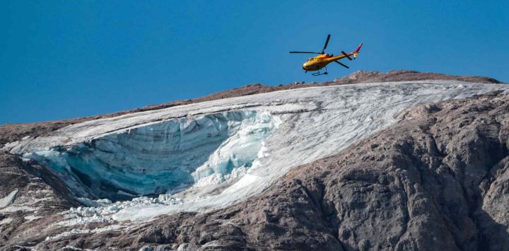 Un helicóptero de rescate vuela sobre el glaciar que se derrumbó en la montaña de Marmolada, la más alta de los Dolomitas. Los equipos de rescate reanudaron la búsqueda de sobrevivientes. Pierre TEYSSOT / AFP.