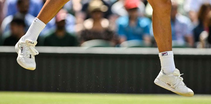 Los zapatos del estadounidense Brandon Nakashima se muestran mientras salta para devolverle la pelota al australiano Nick Kyrgios durante su partido de tenis individual masculino de octavos de final en el octavo día del Campeonato de Wimbledon. Glyn KIRK / AFP.
