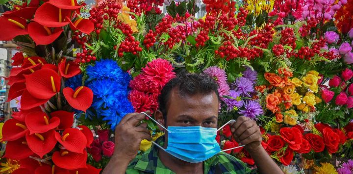 Un vendedor de flores artificiales usa máscaras faciales distribuidas por trabajadores de la salud como protocolo de seguridad para frenar la propagación del coronavirus Covid-19 en Kolkata. DIBYANGSHU SARKAR / AFP.