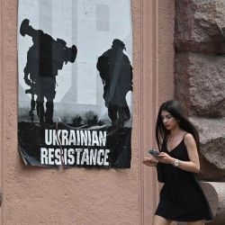 Una mujer pasa junto a un cartel que dice "Resistencia ucraniana" en Kyiv, en medio de la invasión rusa de Ucrania. Serguéi SUPINSKY / AFP. | Foto:AFP