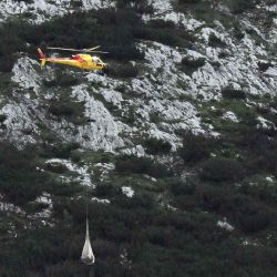 Un helicóptero transporta tubos con sensores remotos para monitorear el glaciar Marmolada. Ocho personas resultaron heridas y otras 14 fueron reportadas como desaparecidas. Tiziana FABI /AFP. | Foto:AFP