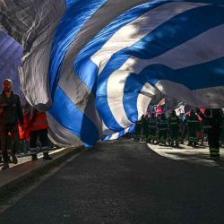 Los trabajadores ondean una gran bandera uruguaya mientras se reúnen en la plaza Independencia durante un paro nacional en Montevideo. Después de la publicación del informe de rendición de cuentas del gobierno, alegando precariedad laboral y aumentos constantes de tarifas. Pablo PORCIUNCULA / AFP. | Foto:AFP