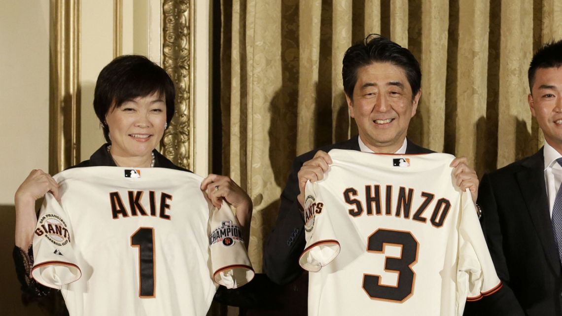 Shinzo Abe, Japan's prime minister, second left, and his wife Akie Abe, left, pose for a photograph while receiving San Francisco Giants baseball jerseys from Giants outfielder Nori Aoki, second from right, and his wife Sachi Ohtake Aoki at the Fairmont Hotel in San Francisco, California, U.S., on Thursday, April 30, 2015. Abe – Japan's longest-serving premier and a figure of enduring influence -- died after being shot at a campaign event on Friday. July 8, 2022, in an attack that shocked a nation where political violence and guns are rare.