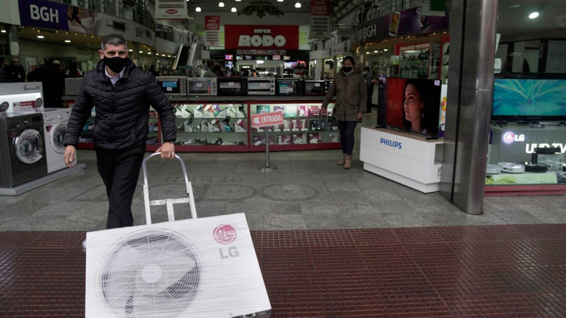 A shopper leaves a consumer electronics store in Buenos Aires on July 6.