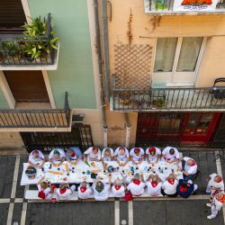 La gente come un almuerzo tradicional en una calle durante las fiestas de San Fermín en Pamplona, norte de España. | Foto:MIGUEL RIOPA / AFP