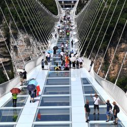 Turistas caminan sobre un puente con piso de cristal en el Gran Cañón de Zhangjiajie, en la provincia de Hunan, en el centro de China. Mientras las vacaciones de verano se acercan, Zhangjiajie, un destino turístico popular en la provincia de Hunan, ha implementado una serie de medidas para impulsar la recuperación del turismo. | Foto:Xinhua/Zhao Zhongzhi