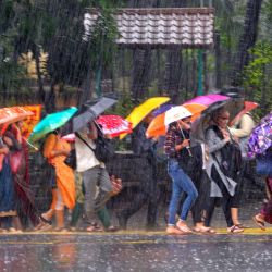 Los transeúntes se abren paso por una calle en medio de las fuertes lluvias en Mumbai, India. | Foto:INDRANIL MUKHERJEE / AFP