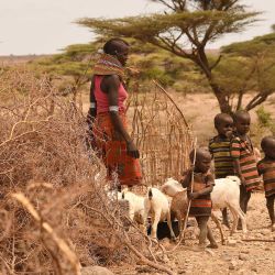 Una madre y sus hijos miran en la zona de Loiyangalani donde se alojan las familias afectadas por la prolongada sequía, en la aldea de Parapul, en Marsabit, norte de Kenia. | Foto:Simon Maina / AFP