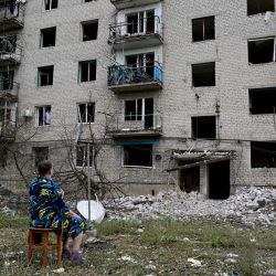 Una mujer sentada frente a su edificio, parcialmente destruido tras el impacto de un misil ruso en un edificio residencial de cuatro plantas en Chasiv Yar, distrito de Bakhmut, este de Ucrania. - Al menos seis personas murieron y otras cinco resultaron heridas en el ataque ruso, dijo un funcionario local. | Foto:MIGUEL MEDINA / AFP
