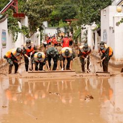 Esta foto muestra a policías paramilitares limpiando una calle tras las inundaciones en Longnan, en la provincia noroccidental china de Gansu. | Foto:AFP