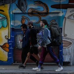 Personas caminan frente a un mural, en la ciudad de Valparaíso, Chile. | Foto:Xinhua/Jorge Villegas