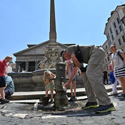 Turistas se refrescan y beben agua de una fuente frente al Panteón, en el centro de Roma, en medio de una feroz ola de calor que recorre Europa. | Foto:ANDREAS SOLARO / AFP