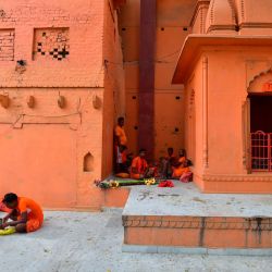 Los devotos del Señor hindú Shiva 'Kanwariya' comen alimentos fuera de un templo mientras llegan a recoger agua del río Ganges para su paseo ritual hacia Varanasi, durante el mes sagrado de Shravan, en Allahabad, India. | Foto:SANJAY KANOJIA / AFP