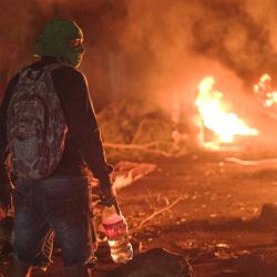 Un manifestante se encuentra frente a neumáticos quemados durante una protesta contra los precios de los combustibles en Santiago, provincia de Veraguas, Panamá. | Foto:Mauricio Valenzuela / AFP