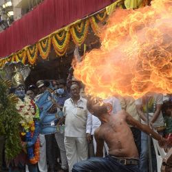 Artistas vestidos como las diosas hindúes Maha Kali actúan junto a un hombre que realiza una acrobacia con fuego durante la procesión del festival Bonalu en el templo Sri Ujjaini Mahakali en Secunderabad, la ciudad gemela de Hyderabad, India. | Foto:NOAH SEELAM / AFP