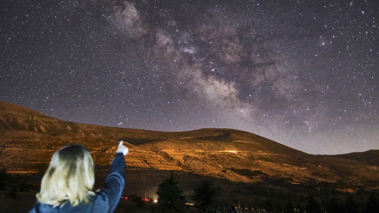 Esta foto de larga exposición, muestra a una niña señalando la galaxia Vía Láctea en el cielo sobre la reserva forestal de cedros, también conocida como los Cedros de Dios, cerca de la ciudad de Bcharre en el monte Líbano, al norte de la capital Beirut. | Foto:Ibrahim Chalhoub / AFP