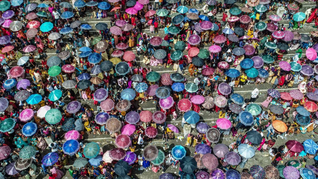 Esta imagen aérea muestra a los espectadores que llevan paraguas reunidos durante el festival anual de Behdienkhlam que se celebra anualmente después del período de siembra en el pueblo de Tuber en el estado nororiental indio de Meghalaya. | Foto:BIJU BORO / AFP