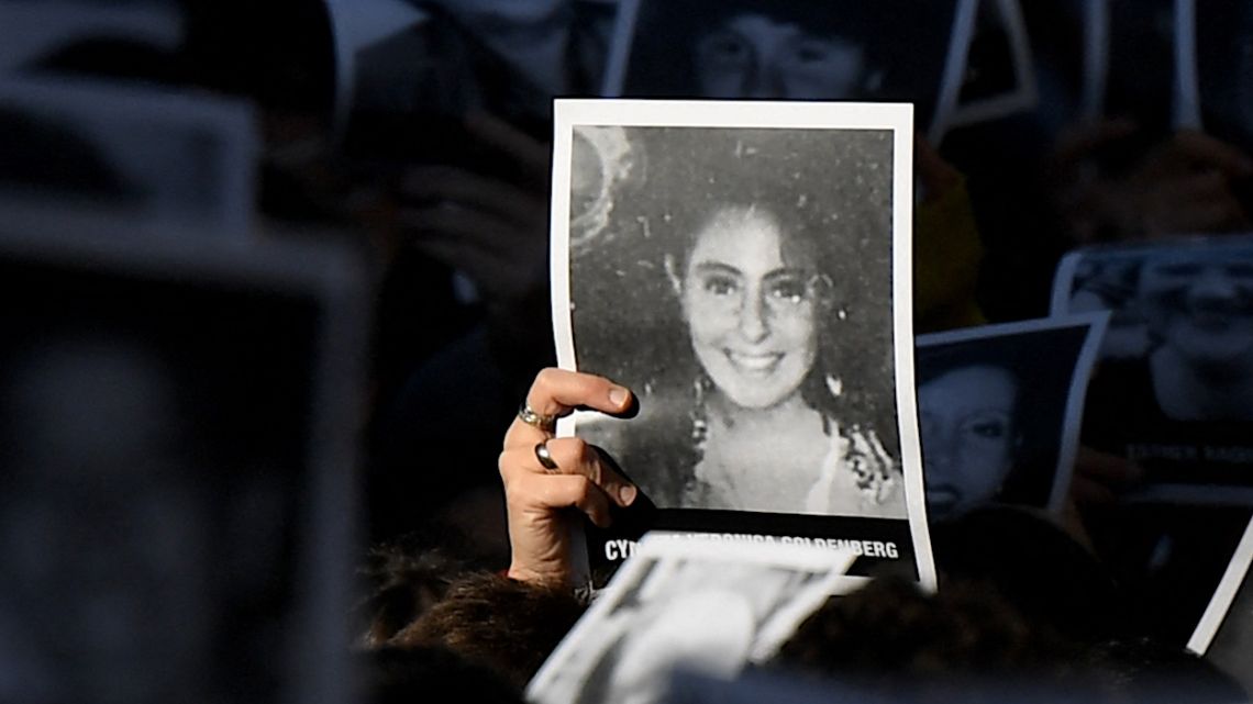 Relatives of victims of a bomb attack to the Jewish community centre of the Mutual Israelite Association of Argentina (AMIA) that killed 85 people and injured 300, hold photos during its 28th anniversary, in Buenos Aires, Argentina, on July 18, 2022. The Israeli intelligence service released controversial new information about how the attack was carried out.