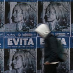 Un hombre pasa junto a los carteles que representan a la ex primera dama argentina Eva Perón, en Buenos Aires, durante el 70º aniversario de su muerte. | Foto:LUIS ROBAYO / AFP