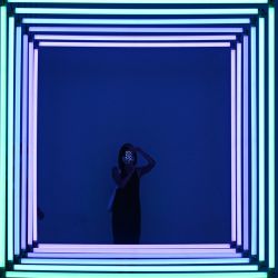 Una mujer utiliza su teléfono móvil para hacer una foto de "Spectrum" de Olivier Ratsi mientras visita una exposición en un museo de Pekín. | Foto:Wang Zhao / AFP