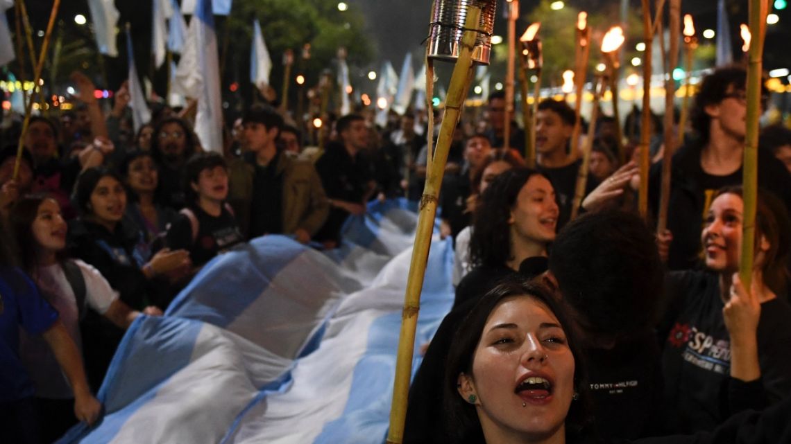 Workers and members of social organizations take part in a march with torches along 9 de Julio Avenue on the 70th anniversary of the death of former First Lady (1946-1952) Eva Peron, in Buenos Aires on July 26, 2022. Crisis-wracked Argentina on Tuesday marked the 70th anniversary of the death of iconic political figure Eva Peron with a series of events, marches and tributes. Known affectionately as "Evita", Maria Eva Duarte de Peron became a legend due to her fight for women's rights and her premature death in 1952 aged just 33.
