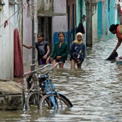 Los residentes vadean una calle inundada tras las fuertes lluvias en Hyderabad, India. | Foto:NOAH SEELAM / AFP