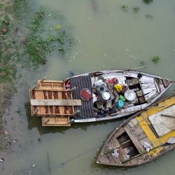 La gente traslada sus pertenencias desde una zona inundada a orillas del río Ganges tras las fuertes lluvias monzónicas en Allahabad, India. | Foto:SANJAY KANOJIA / AFP