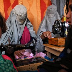 Mujeres afganas vestidas con burka trabajan en una fábrica de ropa en Kandahar. | Foto:LILLIAN SUWANRUMPHA / AFP