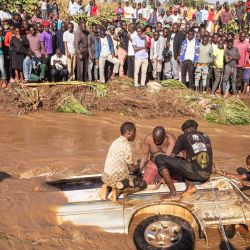 Los aldeanos intentan recuperar los cuerpos de 14 personas de un minibús en el río Nabuyonga en Namakwekwe, al este de Uganda. - El número de personas muertas en las inundaciones repentinas en la ciudad oriental ugandesa de Mbale ha aumentado a 22, incluyendo un grupo de asistentes a una fiesta que quedaron atrapados en un minibús, dijo la policía. | Foto:BADRU KATUMBA / AFP