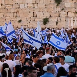 Manifestantes se reúnen con banderas israelíes en el Muro de las Lamentaciones, en la ciudad vieja de Jerusalén, durante la "marcha de las banderas" israelíes para celebrar el "Día de Jerusalén". | Foto:GIL COHEN-MAGEN / AFP