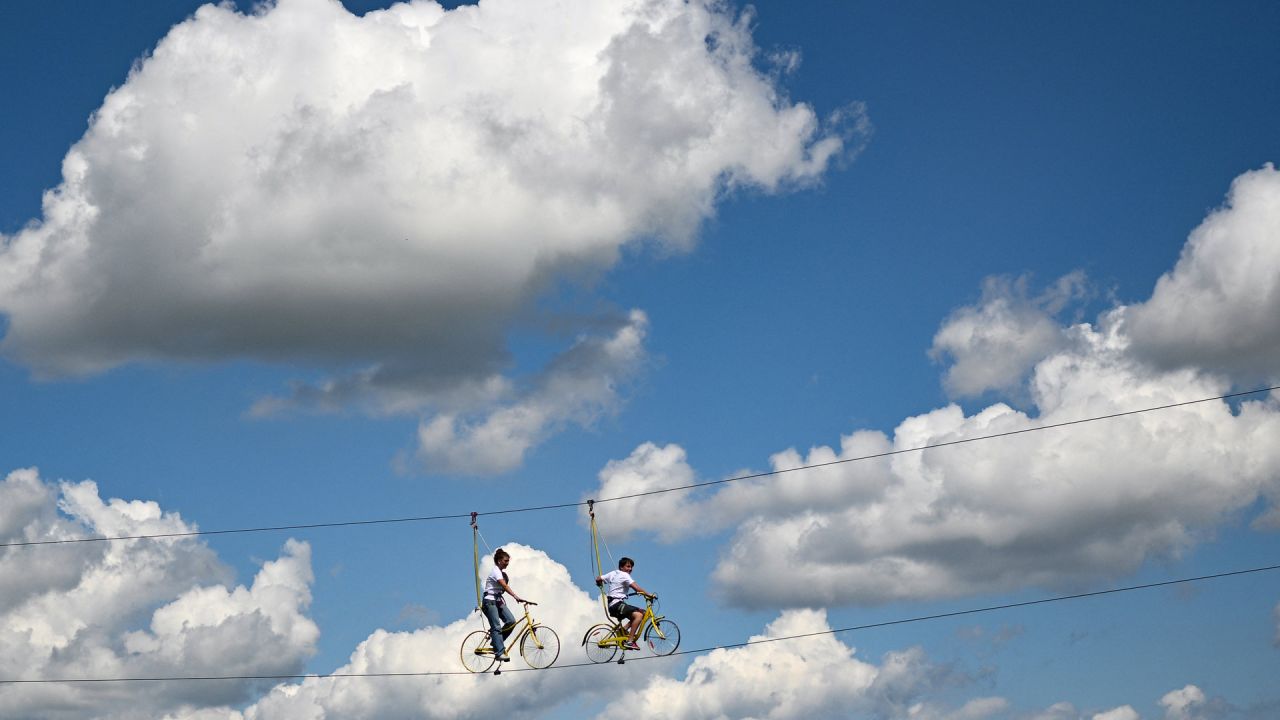 Espectadores pedalean en una cuerda floja a lo largo del recorrido de la 2ª etapa de la 109ª edición de la carrera ciclista del Tour de Francia, 202,2 km entre Roskilde y Nyborg, en Dinamarca. | Foto:MARCO BERTORELLO / AFP
