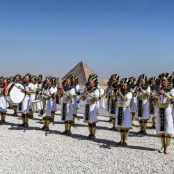 Miembros de una banda de música vestidos con ropas egipcias antiguas actúan antes del espectáculo aéreo de las Pirámides 2022 en la Necrópolis de las Pirámides de Guiza, en las afueras del suroeste de la capital egipcia. | Foto:Mahmoud Khaled / AFP