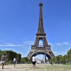 La gente camina por el Campo de Marte seco frente a la Torre Eiffel. | Foto:ALAIN JOCARD / AFP