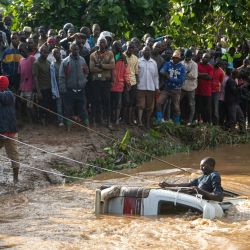 Los aldeanos tratan de recuperar los cuerpos de 14 personas de un minibús en el río Nabuyonga en Namakwekwe, al este de Uganda. - El número de muertos por las inundaciones repentinas en la ciudad de Mbale, en el este de Uganda, ha aumentado a 22, entre ellos un grupo de asistentes a una fiesta que quedó atrapado en un minibús, según informó la policía. | Foto:BADRU KATUMBA / AFP