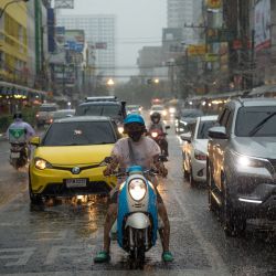 Los automovilistas esperan en un semáforo en rojo durante una fuerte lluvia en Bangkok, Tailandia. | Foto:JACK TAYLOR / AFP
