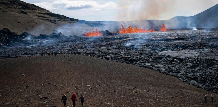 La gente visita la escena del volcán en erupción que tiene lugar en el valle de Meradalir, cerca del monte Fagradalsfjall, Islandia.
