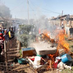 Los miembros de la comunidad de Mohlakeng queman pertenencias de presuntos mineros ilegales en un albergue Mohlakeng, cerca de Randfontein, durante una manifestación de los residentes contra la minería ilegal y el cromo en su área. Phill Magakoe / AFP. | Foto:AFP
