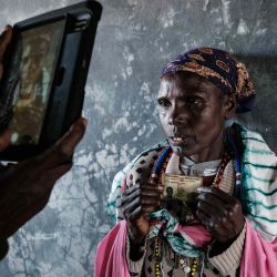 Una mujer maasai sostiene su tarjeta de identificación mientras un presidente le toma una fotografía para informar sobre la falla en el reconocimiento de sus huellas dactilares en el Sistema Integrado de Gestión Electoral de Kenia (KIEMS) en el colegio electoral de la escuela primaria de Nailare en Kilgoris. Yasuyoshi CHIBA / AFP. | Foto:AFP