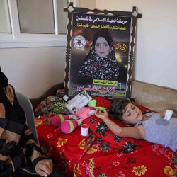 La madre palestina Rasha Qadoom se sienta junto a su hijo herido Rayed cerca de un cartel que representa a su hija Alaa, de cinco años, muerta durante el último conflicto entre Israel y los militantes palestinos, en Gaza. Mahmud JAMONES / AFP. | Foto:AFP