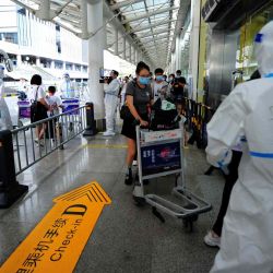 Los turistas realizan los trámites previos a la salida en el aeropuerto de Sanya Phoenix mientras los turistas varados se preparan para abandonar la ciudad turística de Sanya, afectada por Covid, en la isla de Hainan, China. Str / AFP. | Foto:AFp