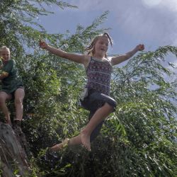 La niña ucraniana Dasha (derecha) salta a un lago mientras Sasha espera en la región de Donbas, en el este de Ucrania, en medio de la invasión militar de Rusia lanzada contra Ucrania. Bulent KILIC / AFP. | Foto:AFP