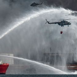 El buque de extinción de incendios mexicano "Bourbon Artabaze" y los helicópteros luchan para contener el incendio de varios días en un depósito de combustible provocado por un rayo en Matanzas, Cuba. Yamil LAGE / AFP. | Foto:AFP