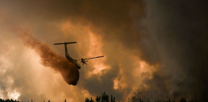 Un avión de extinción de incendios rocía retardante de fuego sobre los árboles durante un incendio forestal cerca de Belin-Beliet en Gironde, suroeste de Francia. Philippe LOPEZ / AFP.