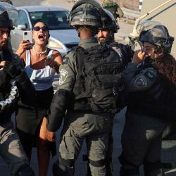 Un colono israelí rodeado por las fuerzas de seguridad israelíes grita a los palestinos que protestan contra los asentamientos judíos, al este de la ciudad ocupada de Qalqilia, en Cisjordania. JAAFAR ASHTIYEH / AFP. | Foto:AFP